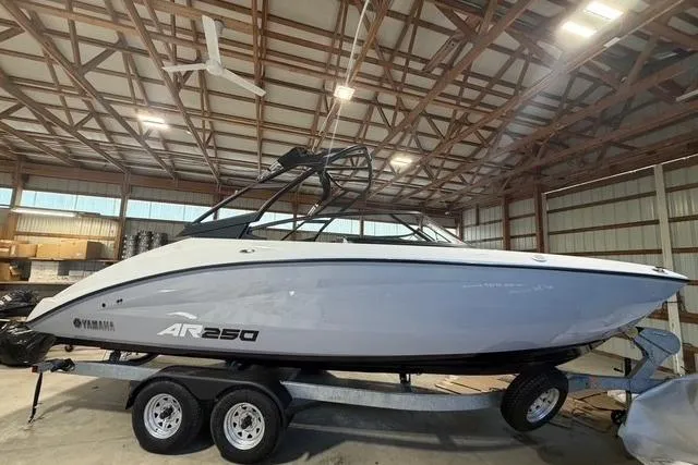 The Image of 2026 Yamaha Boats AR250 in a warehouse, on a trailer, side view. - 0