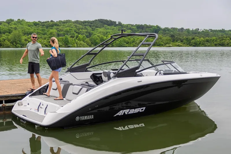Slide: The Image of Manufacturer Provided Image: 2026 Yamaha AR250 boat docked on a serene lake with two people nearby. - 7