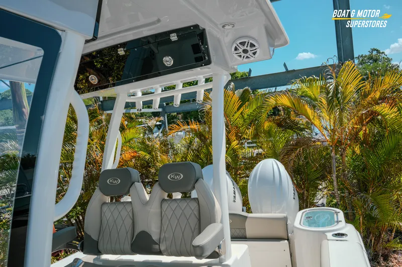 Slide: The Image of 2026 Key West 260 Center Console boat interior with dual seats and tropical background. - 29