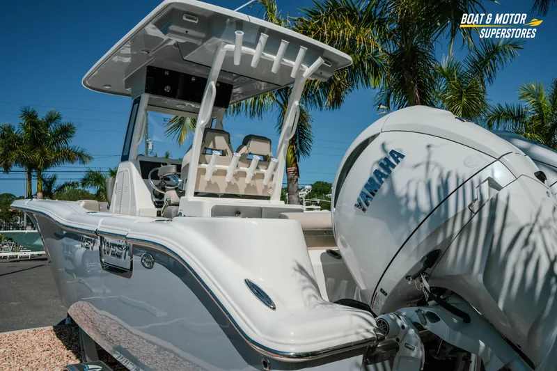 Slide: The Image of 2026 Key West 260 Center Console boat with Yamaha engine, parked under palm trees. - 6