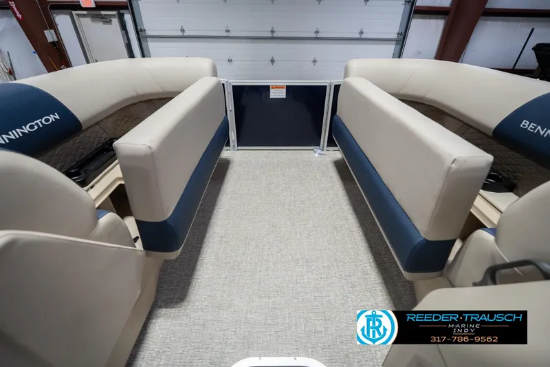 Slide: The Image of 2026 Bennington 21 SLJ boat interior with beige and blue seating in a showroom. - 18