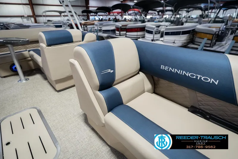 Slide: The Image of 2026 Bennington 21 SLJ boat interior with blue and beige seating in showroom. - 19