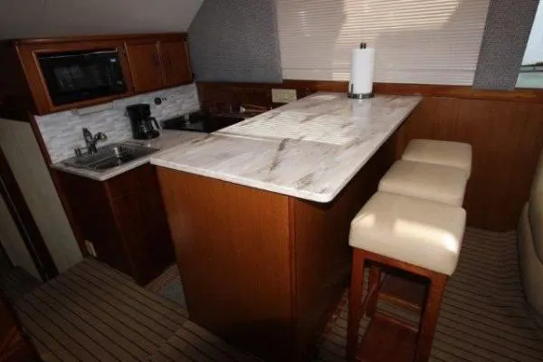 Slide: The Image of Luxurious kitchen interior of 2000 Ocean Yacht 48 Super Sport with marble countertop and wooden cabinetry. - 19