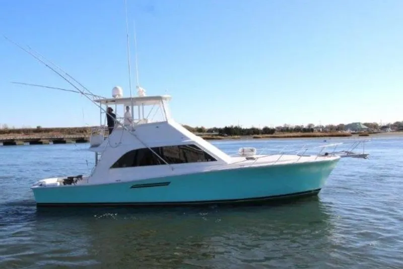 Slide: The Image of 2000 Ocean Yacht 48 Super Sport cruising on calm waters under clear skies. - 2
