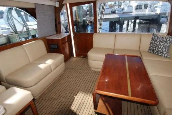 Slide: The Image of Luxurious interior of 2000 Ocean Yacht 48 Super Sport with beige seating and wooden table. - 21