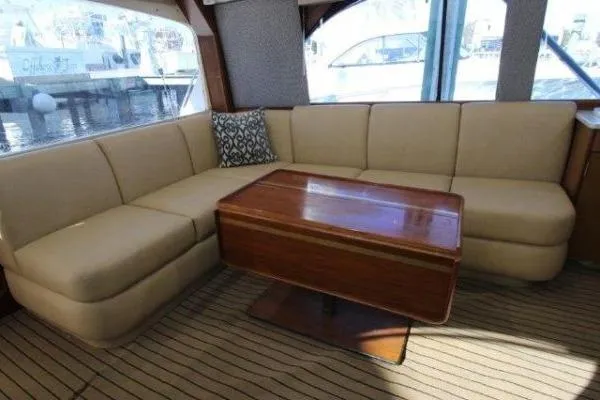 Slide: The Image of Luxurious interior of 2000 Ocean Yacht 48 Super Sport with beige seating and wooden table. - 22