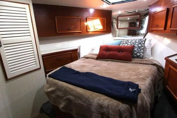Slide: The Image of Cozy bedroom interior of 1990 Ocean Yachts 48 Super Sport with wooden cabinets and plush bedding. - 27