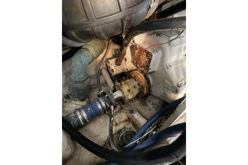 Slide: The Image of Engine compartment of a 1990 Ocean Yachts 48 Super Sport, showing mechanical components and hoses. - 38