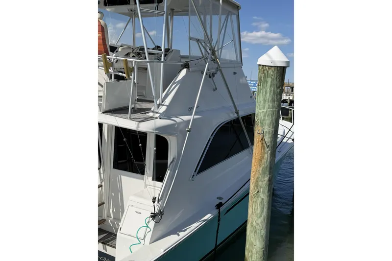 Slide: The Image of 1990 Ocean Yachts 48 Super Sport docked, showcasing sleek design and flybridge. - 8