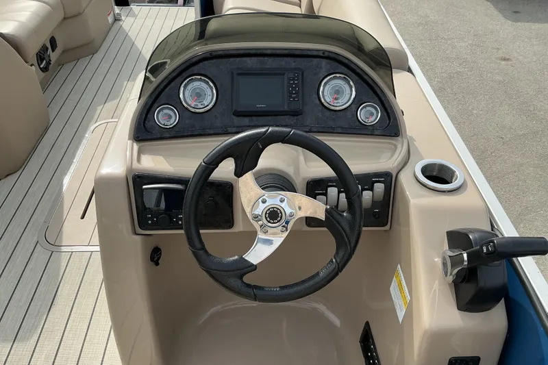 Slide: The Image of 2024 SunCatcher Fusion 322RC boat dashboard with steering wheel and control panel. - 4