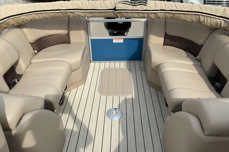 Slide: The Image of 2024 SunCatcher Fusion 322RC boat interior with beige seating and striped flooring. - 7
