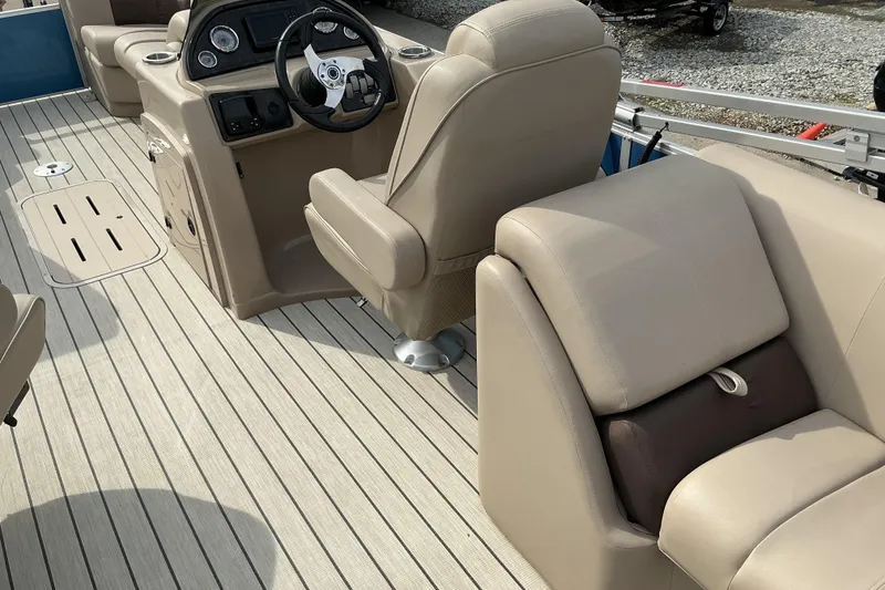 Slide: The Image of 2024 SunCatcher Fusion 322RC boat interior with beige seating and steering console. - 8
