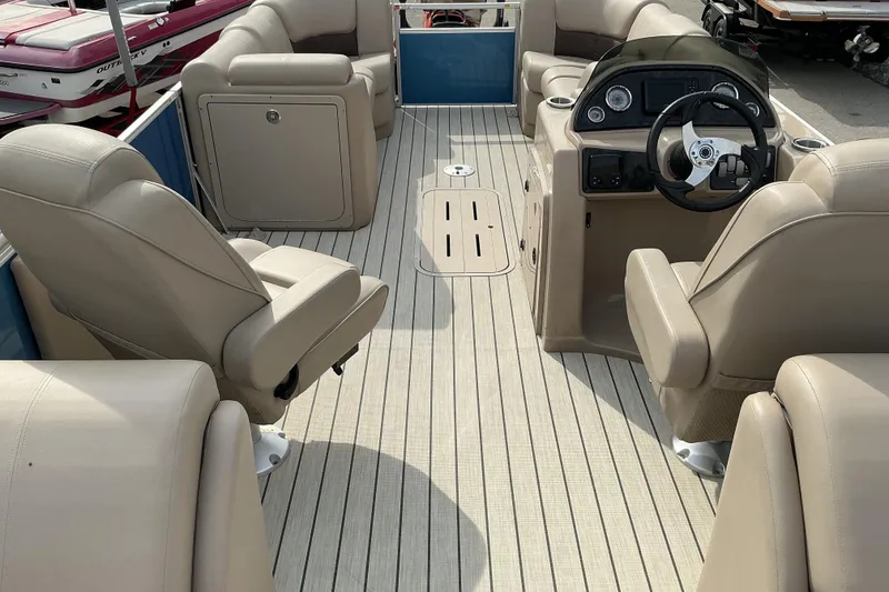 Slide: The Image of 2024 SunCatcher Fusion 322RC boat interior with beige seating and steering console. - 9