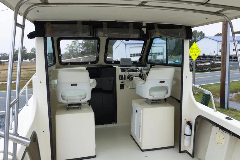 Slide: The Image of Interior view of a 2000 May-Craft 2550 Cabin boat with dual captain chairs. - 10