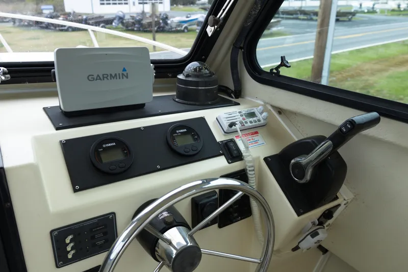 Slide: The Image of May-Craft 2550 Cabin 2000 boat dashboard with Garmin GPS and Yamaha controls. - 11