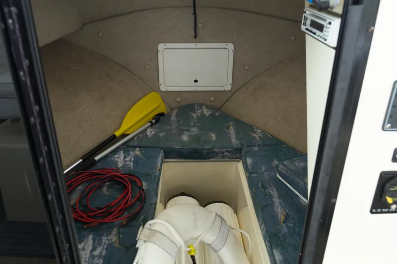 Slide: The Image of Interior of a 2000 May-Craft 2550 Cabin boat with paddle and ropes. - 13