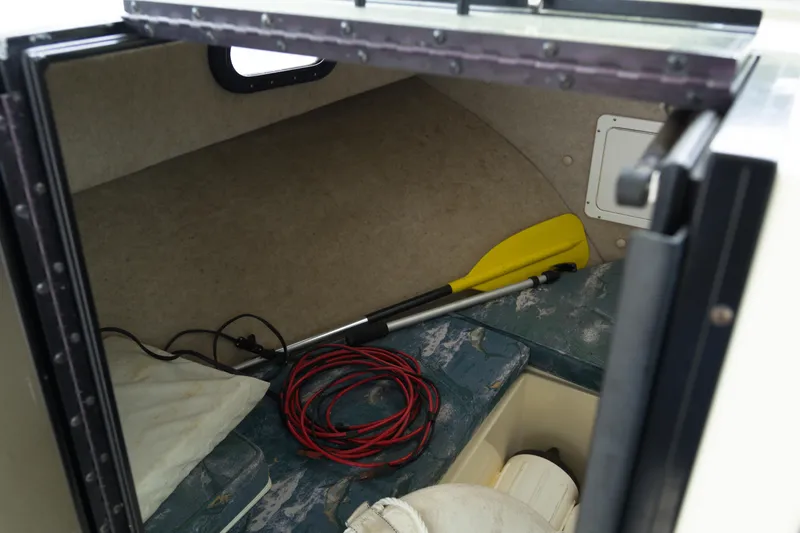Slide: The Image of Interior of a 2000 May-Craft 2550 Cabin boat with paddle and rope. - 14