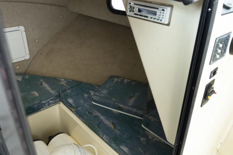 Slide: The Image of Interior cabin of 2000 May-Craft 2550, featuring cushioned seating and control panel. - 15