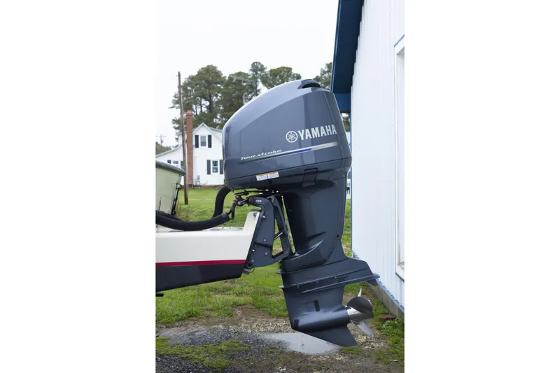 Slide: The Image of Yamaha outboard motor on a 2000 May-Craft 2550 Cabin boat, parked outdoors. - 4