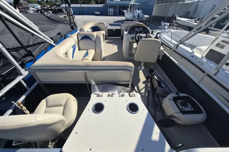Slide: The Image of 2014 SunChaser 8522 C-N-F pontoon boat interior with beige seating and steering console. - 9