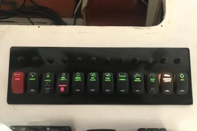 Slide: The Image of Control panel of a 2003 Grady-White Express 330 boat with labeled switches. - 12