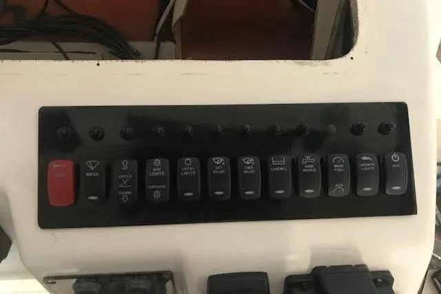 Slide: The Image of Control panel of a 2003 Grady-White Express 330 boat with labeled switches. - 13