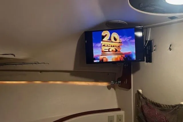 Slide: The Image of 2003 Grady-White Express 330 cabin with wall-mounted TV displaying 20th Century Fox logo. - 21