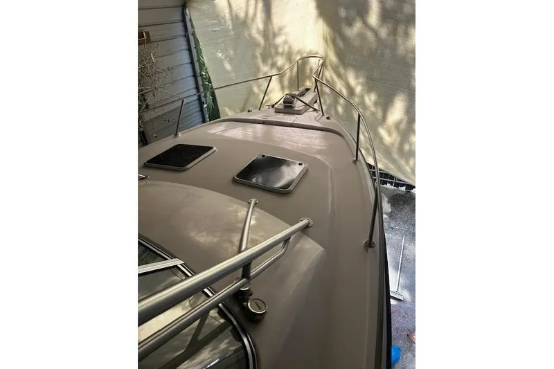 Slide: The Image of 2003 Grady-White Express 330 boat deck with hatches and railings in shaded area. - 25