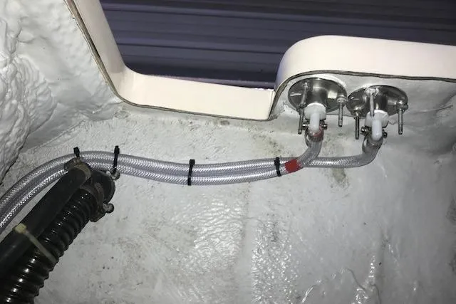 Slide: The Image of Boat plumbing system in a 2003 Grady-White Express 330, featuring hoses and fittings. - 29