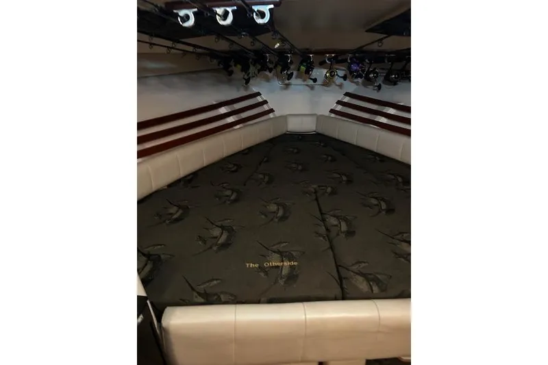 Slide: The Image of 2003 Grady-White Express 330 cabin interior with cushioned seating and fishing rod holders. - 45