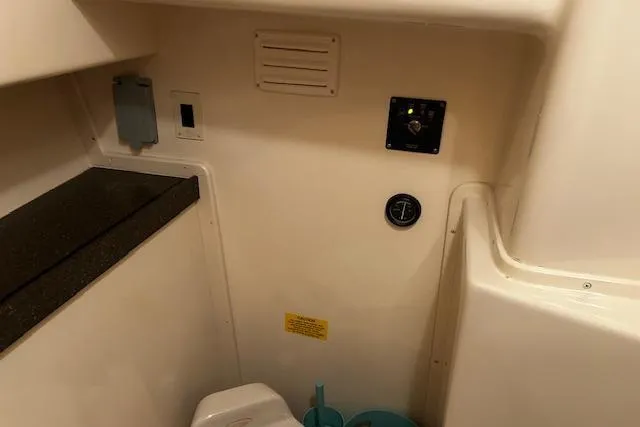 Slide: The Image of 2003 Grady-White Express 330 boat interior with control panel and storage area. - 46