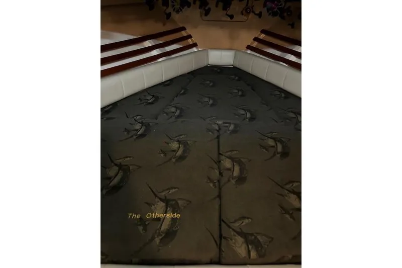 Slide: The Image of 2003 Grady-White Express 330 cabin interior with patterned bedding and cushioned seating. - 49