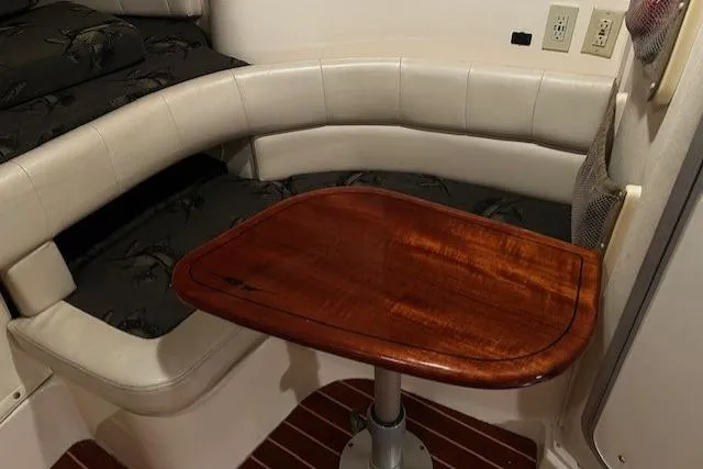 Slide: The Image of 2003 Grady-White Express 330 cabin with wooden table and cushioned seating. - 50