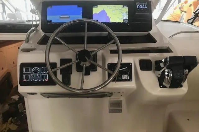 Slide: The Image of 2003 Grady-White Express 330 helm with dual navigation screens and steering wheel. - 7