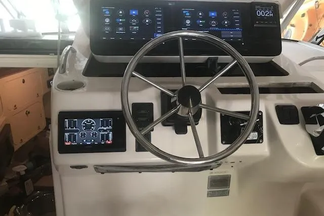 Slide: The Image of Helm of 2003 Grady-White Express 330 with modern navigation displays and steering wheel. - 8