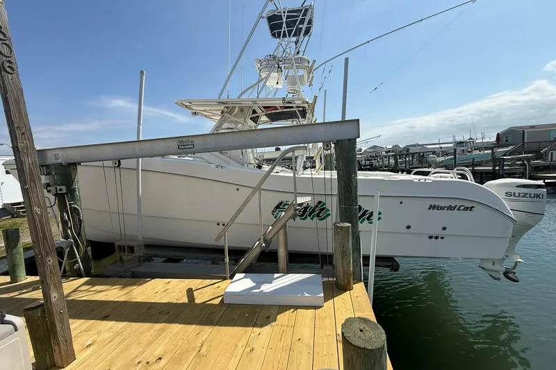 Slide: The Image of 2005 World Cat 330 TE boat docked with Suzuki engines, clear sky background. - 11