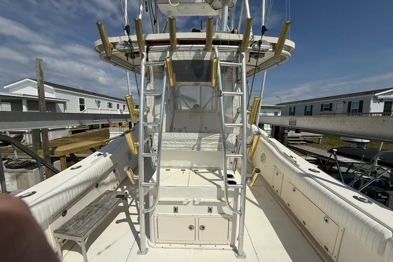 Slide: The Image of 2005 World Cat 330 TE boat deck with ladder and rod holders under clear sky. - 29