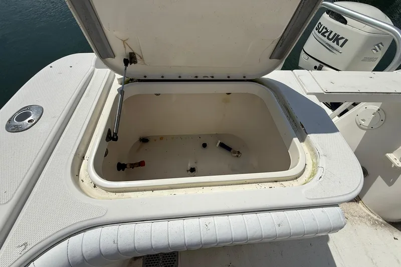 Slide: The Image of Open storage compartment on a 2005 World Cat 330 TE boat with Suzuki engine. - 33