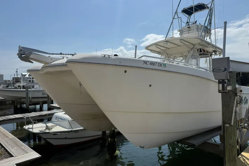Slide: The Image of 2005 World Cat 330 TE boat docked at marina, clear sky background. - 9
