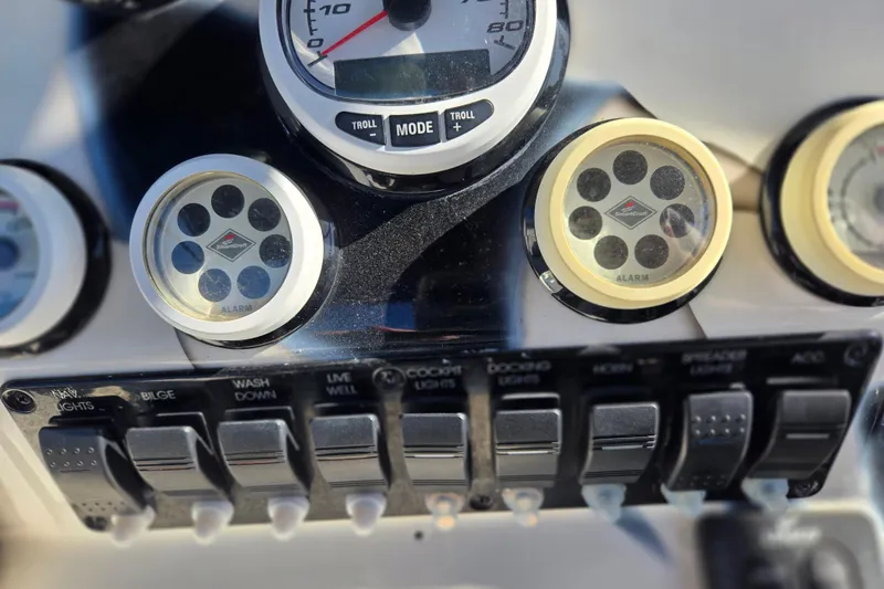 Slide: The Image of Dashboard controls of a 2011 Glasstream 280 SCX boat with gauges and switches. - 16
