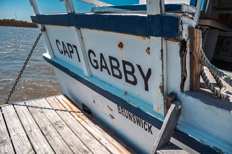 Slide: The Image of 1977 Saint Augustine Trawler 43 docked, displaying "Capt Gabby" and "Brunswick" on the stern. - 11