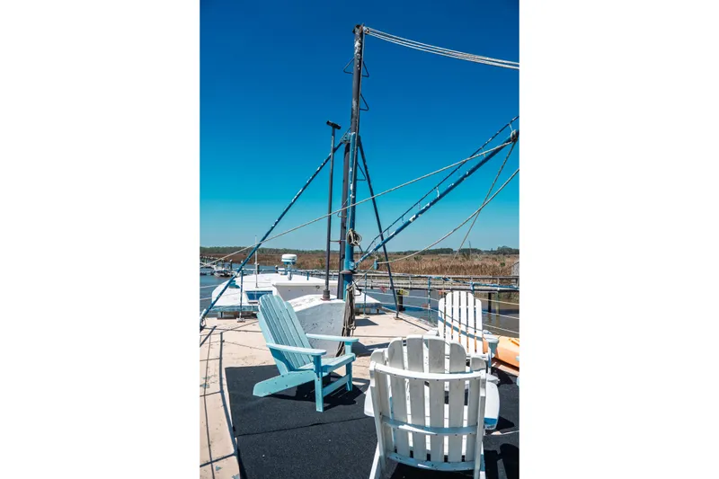 Slide: The Image of 1977 Saint Augustine 43 Trawler deck with chairs under clear blue sky. - 15