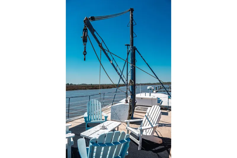 Slide: The Image of 1977 Saint Augustine 43 Trawler deck with chairs and crane, overlooking serene waters. - 21