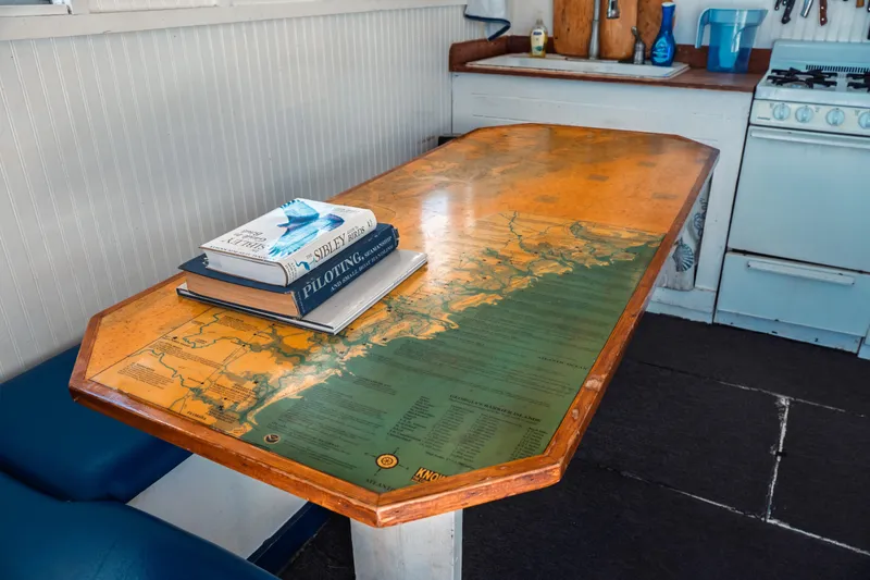 Slide: The Image of 1977 Saint Augustine Trawler interior with map table and nautical books. - 27
