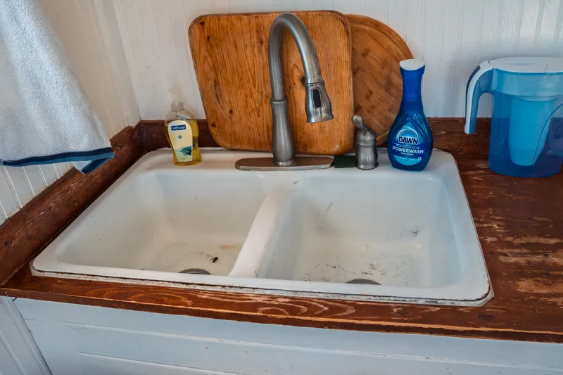 Slide: The Image of Dual kitchen sink with faucet, soap, and cutting boards on a 1977 Saint Augustine Trawler. - 30