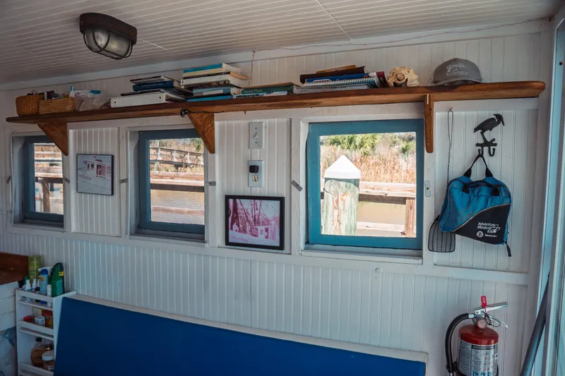 Slide: The Image of Interior of 1977 Saint Augustine 43 Trawler with shelves, windows, and nautical decor. - 32