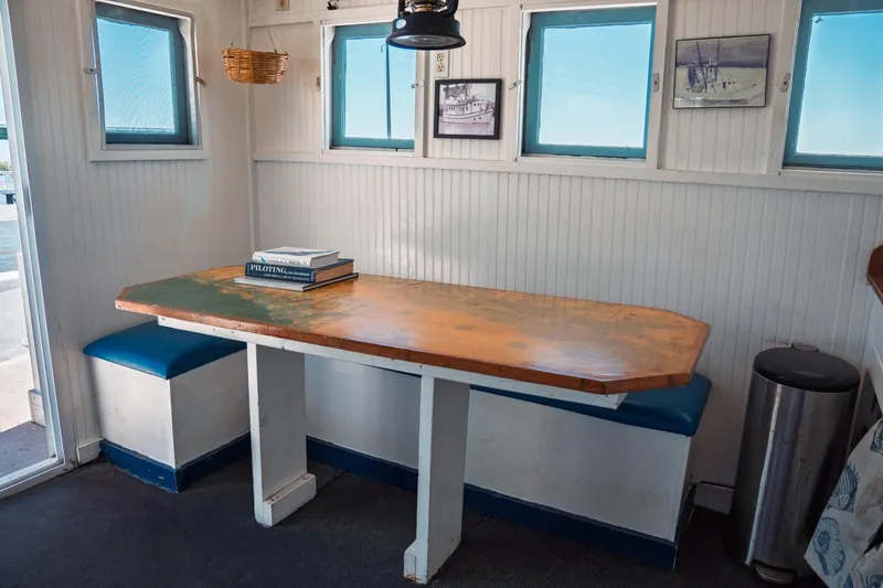 Slide: The Image of 1977 Saint Augustine Trawler 43 interior with wooden table, blue seating, and nautical decor. - 33