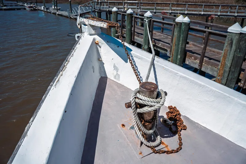 Slide: The Image of Bow of 1977 Saint Augustine 43 Trawler docked, featuring ropes and chains. - 36