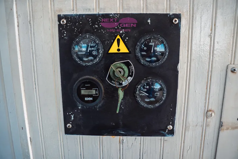 Slide: The Image of Control panel of a 1977 Saint Augustine Trawler 43, featuring gauges and warning symbol. - 48