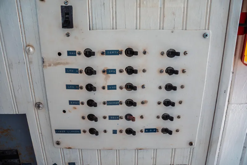 Slide: The Image of Control panel on a 1977 Saint Augustine 43 Trawler, featuring labeled switches. - 49